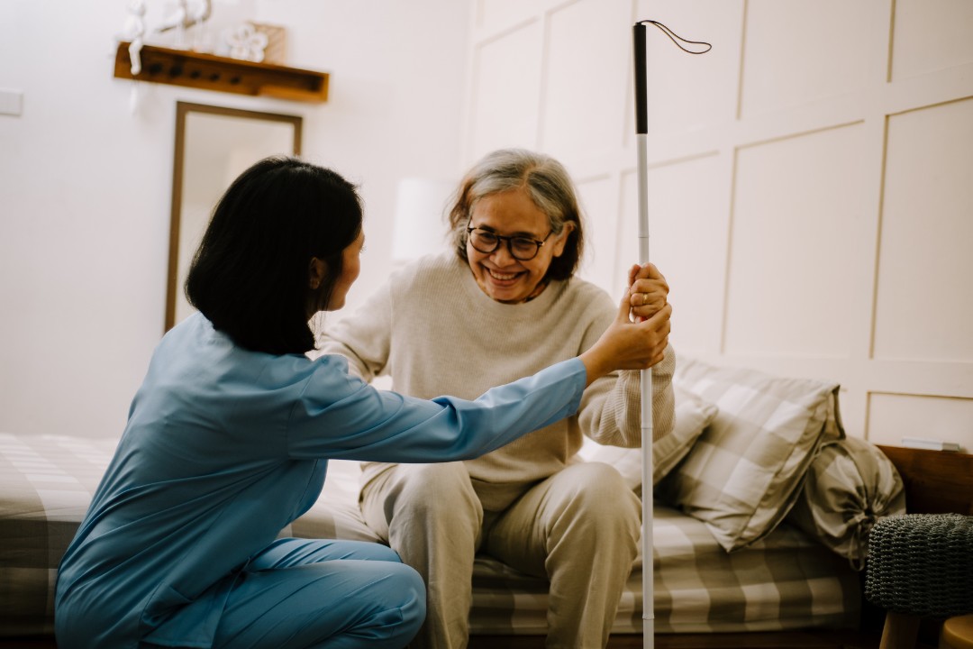 A carer assisting her service user, helping her to get back up onto her feet.