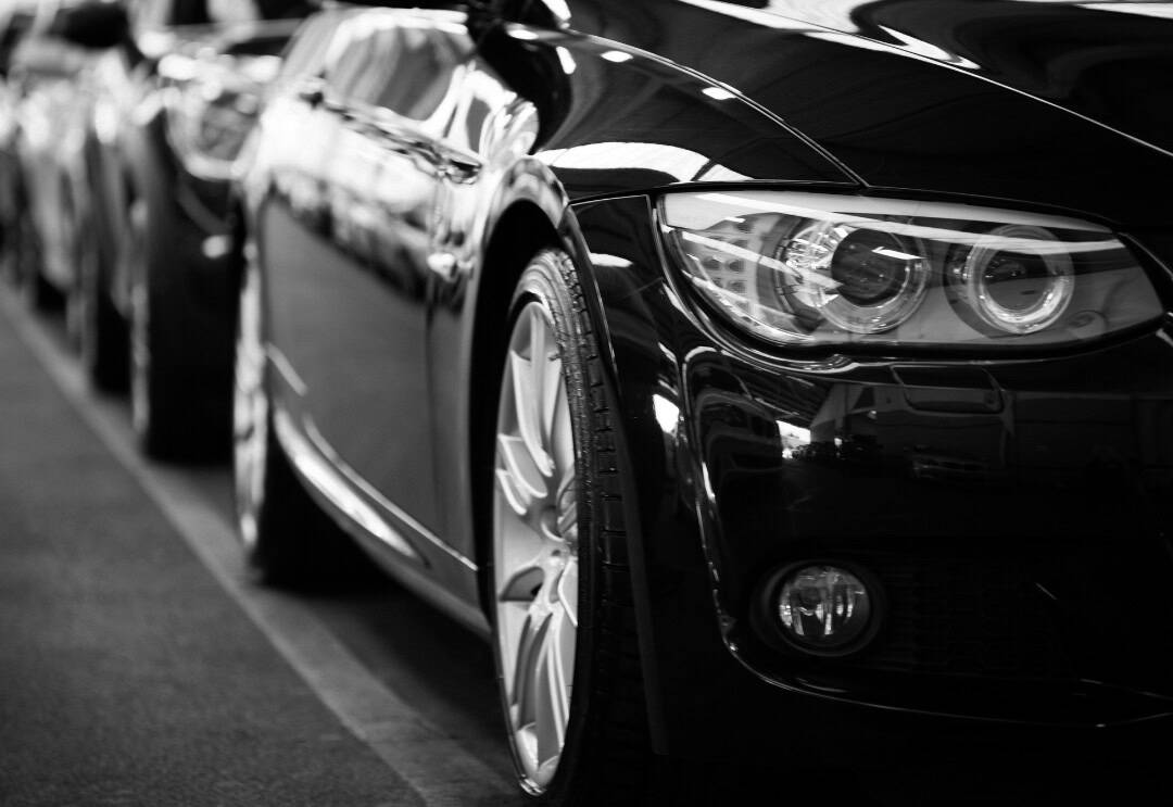 Black car close up of its side with another black car directly behind it.